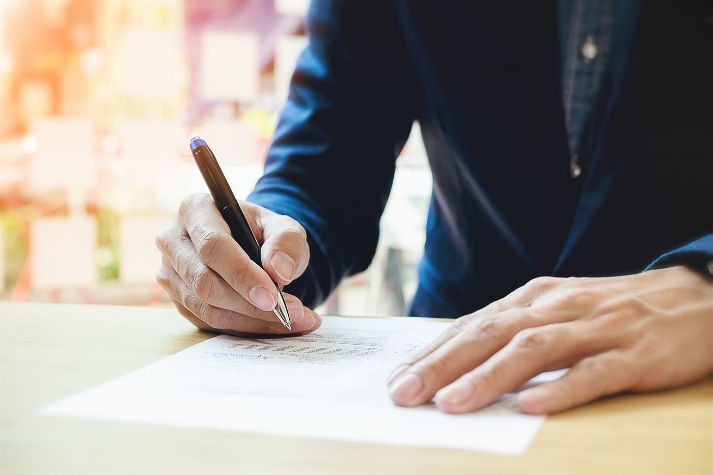 Signer signing a document with a pen